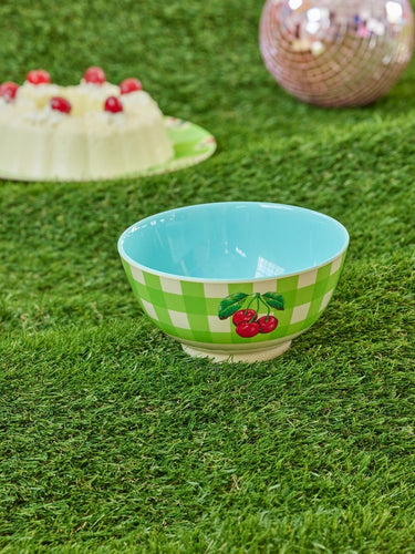 Grüner Melamin-Teller mit elegantem Design und glänzender Oberfläche. Innen hellblau und außen grün, weiß karriert mit drei roten Kirschen. von Rice by Rice.